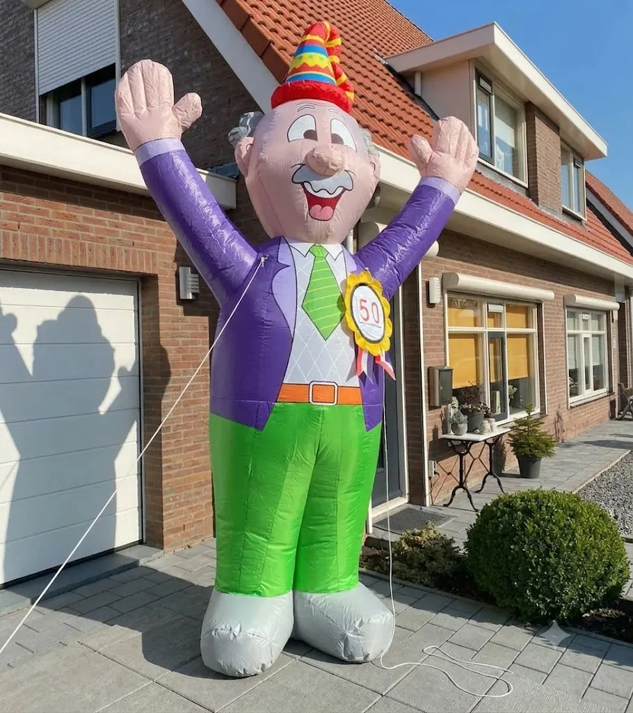 Opblaasfiguur Abraham met paarse jas, feesthoed en groene broek in een Terneuzense voortuin